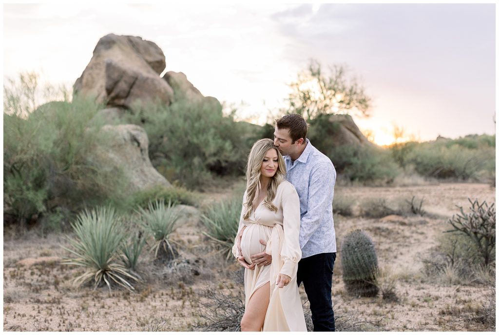 towering boulders in the glowing desert of Arizona Maternity session